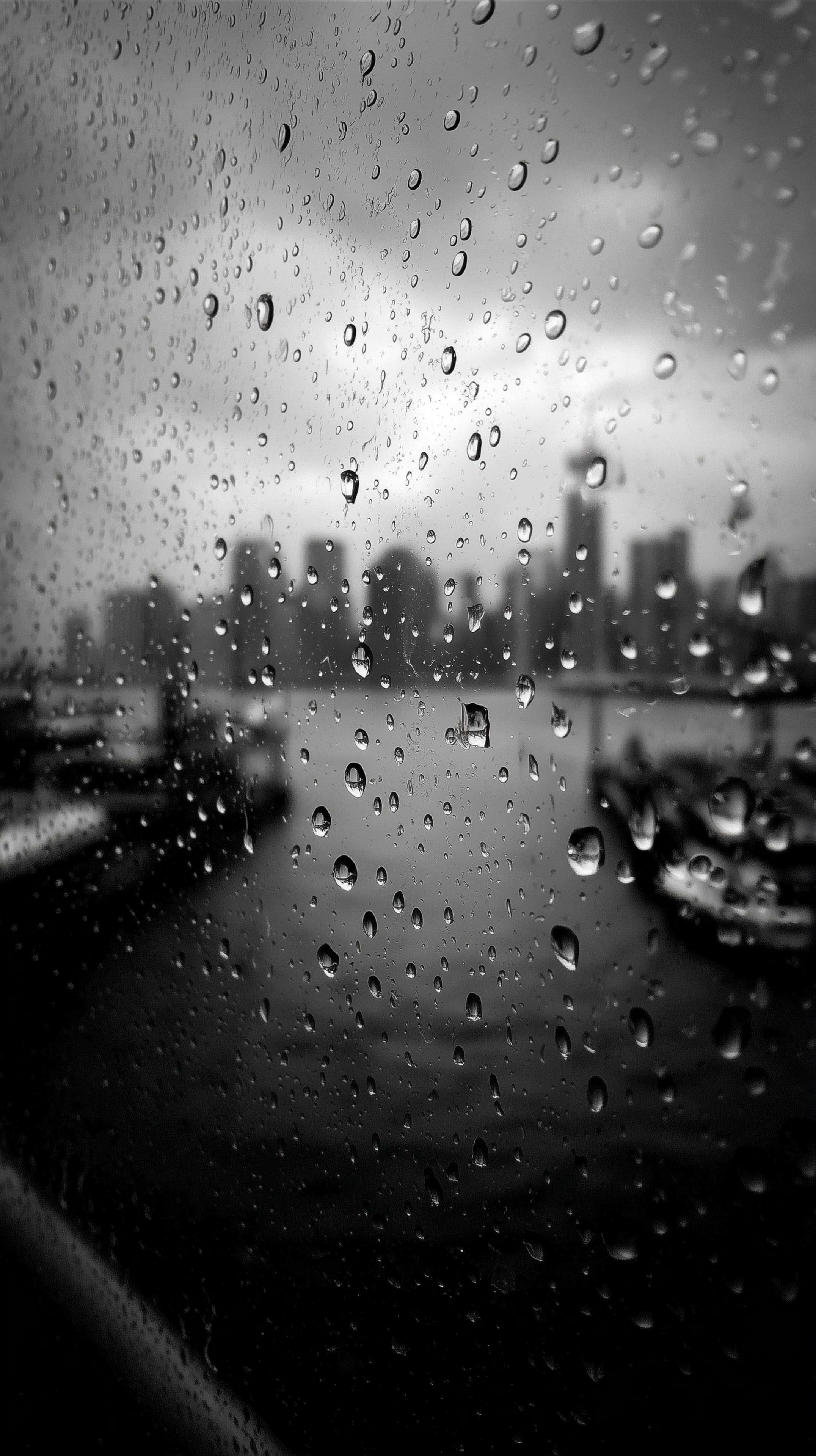 Monochrome Rainy Cityscape Through Rainy Glass Window - High Resolution atmospheric Wallpaper for Mobile and Desktop